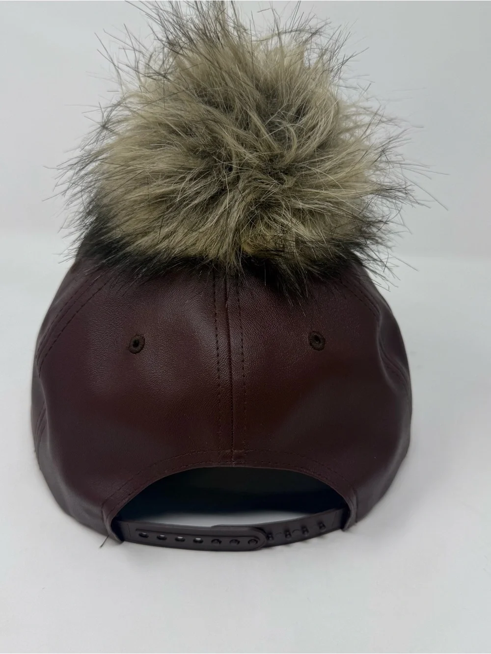 faux leather baseball cap by Premium Hatco features a faux fur pompom